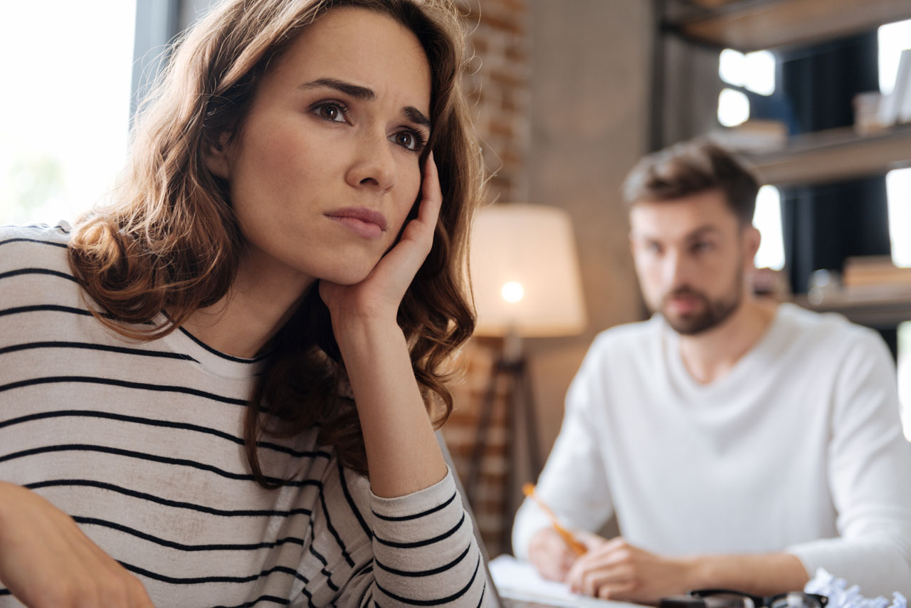Thoughtful look. Depressed cheerless unhappy woman holding her chin and thinking about her problems while having a difficult period in life