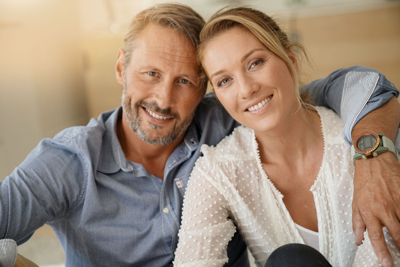 Mature couple relaxing at home, looking at camera